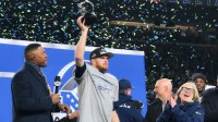 Seattle Seahawks quarterback Sam Darnold (14) celebrates with the trophy on the podium after defeating the Los Angeles Rams in the 2026 NFC Championship Game at Lumen Field. Mandatory Credit: Steven Bisig-Imagn Images
