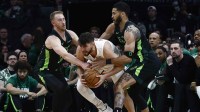Cleveland Cavaliers guard Ty Jerome (2) tries to get away from Boston Celtics forward Jayson Tatum (0) and forward Sam Hauser (30) during the first quarter at TD Garden.