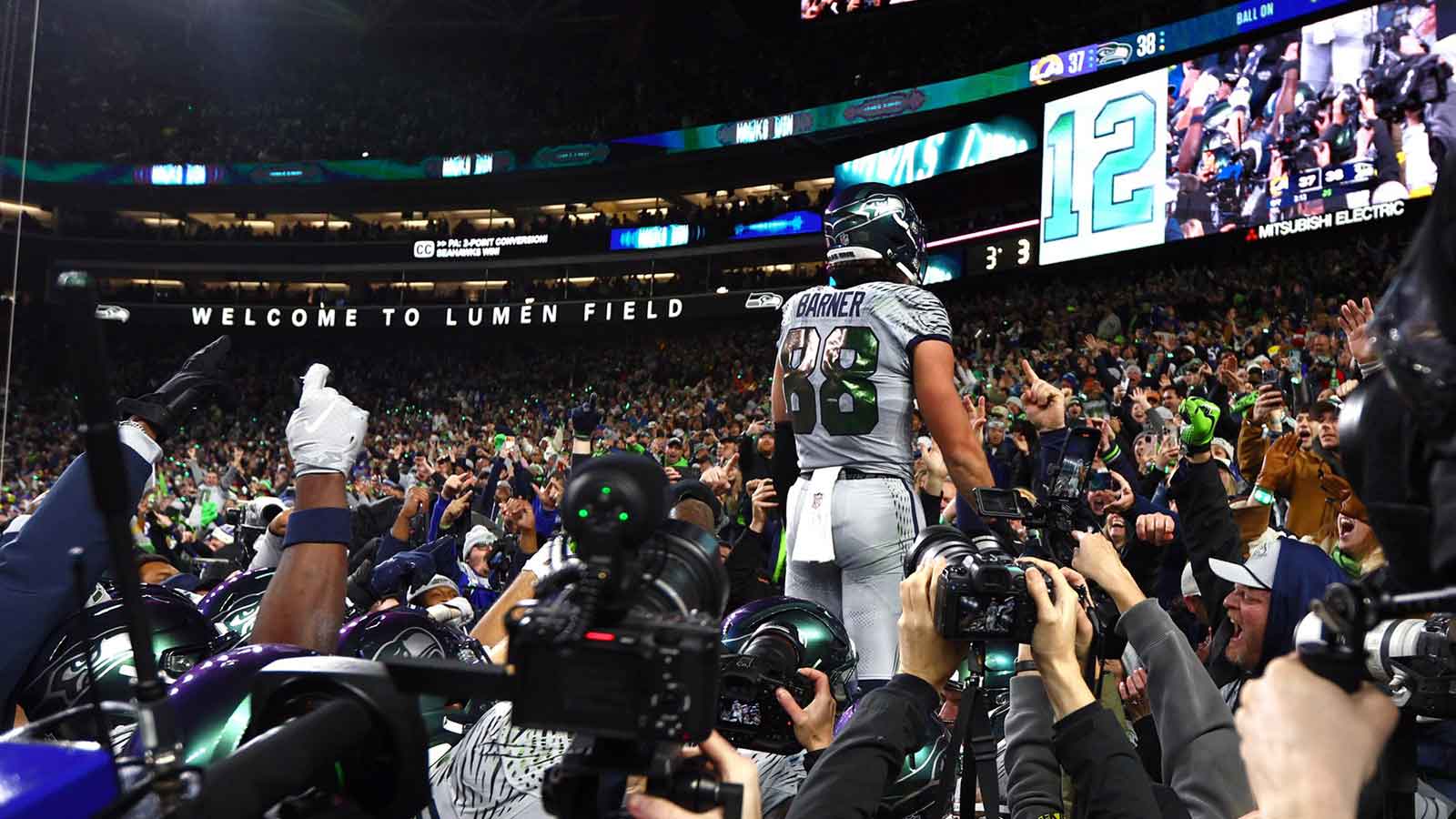 Seattle Seahawks tight end AJ Barner (88) celebrates with fans after defeating the Los Angeles Rams in overtime at Lumen Field.