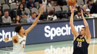 Nuggets center Nikola Jokic (15) shoots the ball over San Antonio Spurs center Victor Wembanyama (1) during the second half at Frost Bank Center with the Thunder logo & Charles Barkley in the background