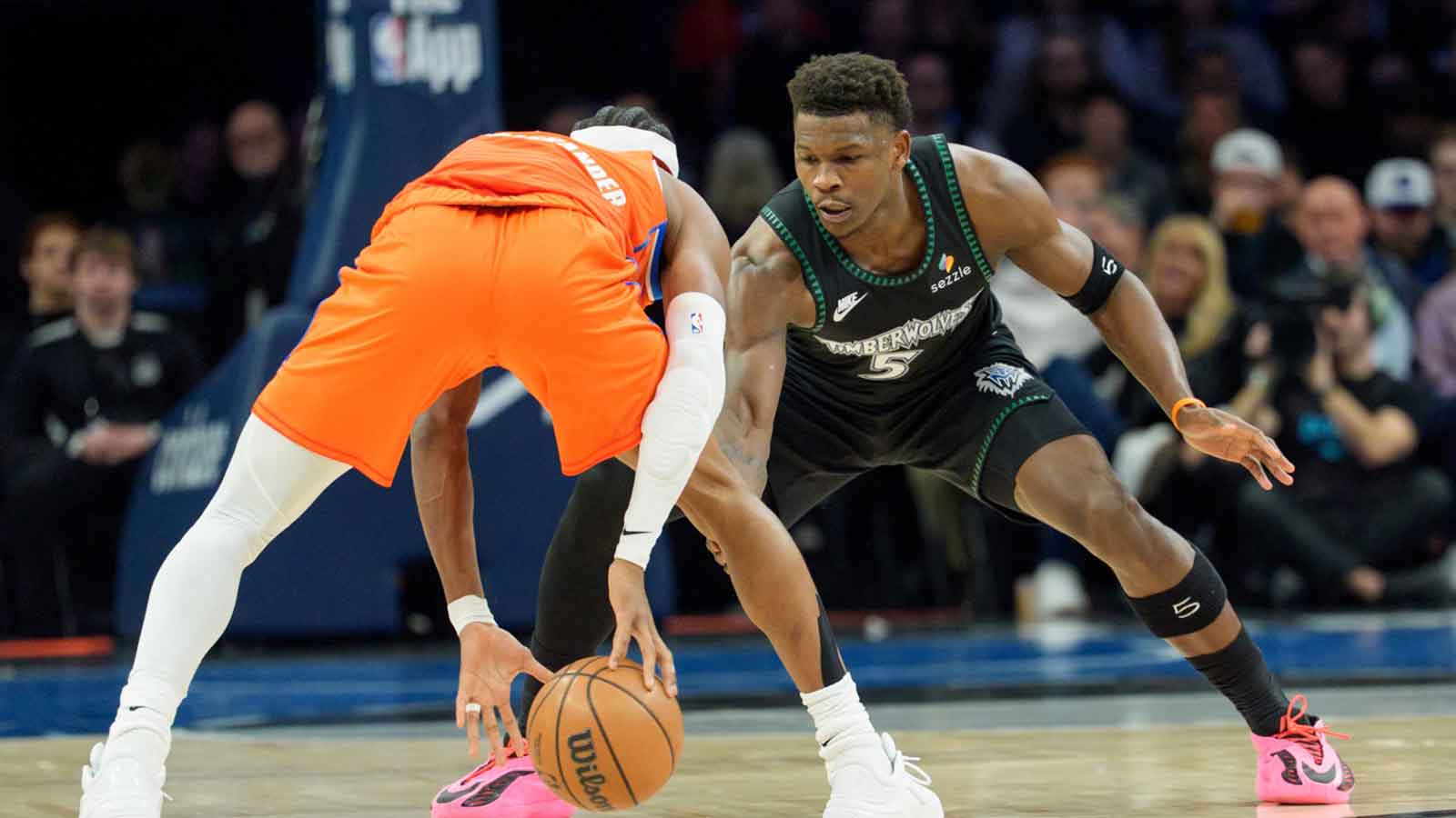 Minnesota Timberwolves guard Anthony Edwards (5) defends Oklahoma City Thunder guard Shai Gilgeous-Alexander (2) in the first quarter at Target Center.