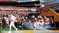 Texas Longhorns head coach Steve Sarkisian, Texas Longhorns wide receiver Parker Livingstone (13) and offensive lineman Brandon Baker (73) run onto the field before a game against the Michigan Wolverines at Camping World Stadium.