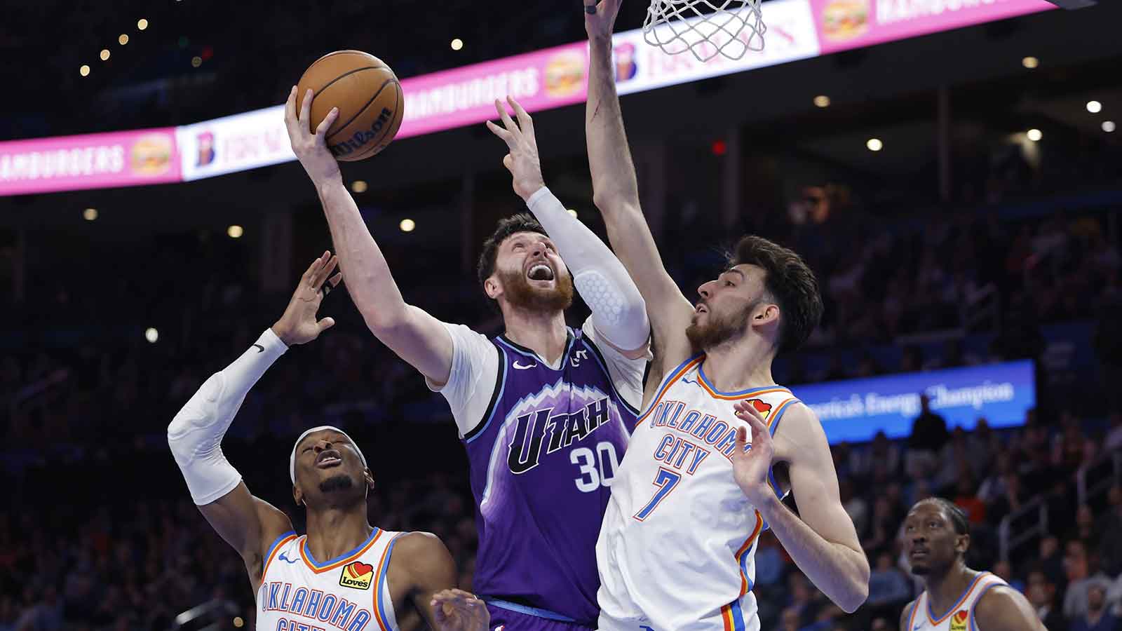 Jazz center Jusuf Nurkić (30) shoots between Oklahoma City Thunder guard Shai Gilgeous-Alexander (2) and center/forward Chet Holmgren (7) during the second half at Paycom Center
