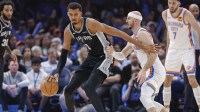Spurs forward Victor Wembanyama (1) moves the ball across the court against Oklahoma City Thunder guard Alex Caruso (9) during the second half at Paycom Center