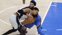 Thunder guard/forward Kenrich Williams (34) and San Antonio Spurs forward/center Victor Wembanyama (1) fight for a loose ball during the second half at Paycom Center