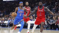 Thunder guard Shai Gilgeous-Alexander (2) drives to the basket beside New Orleans Pelicans forward Zion Williamson (1) during the second half at Paycom Center with Thunder's Lu Dort & Pelicans' Jeremiah Fears in the background