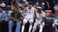 Thunder guard Jalen Williams (8), center Chet Holmgren (7), and guard Shai Gilgeous-Alexander (2) talk while sitting on the bench during the fourth quarter against the Los Angeles Lakers at Paycom Center with Michael Jordan and Stephen Curry in the background