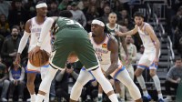 Thunder guard Lu Dort (5) plays defense against Milwaukee Bucks forward Giannis Antetokounmpo (34) with Thunder guard Shai Gilgeous-Alexander in the first half at Fiserv Forum