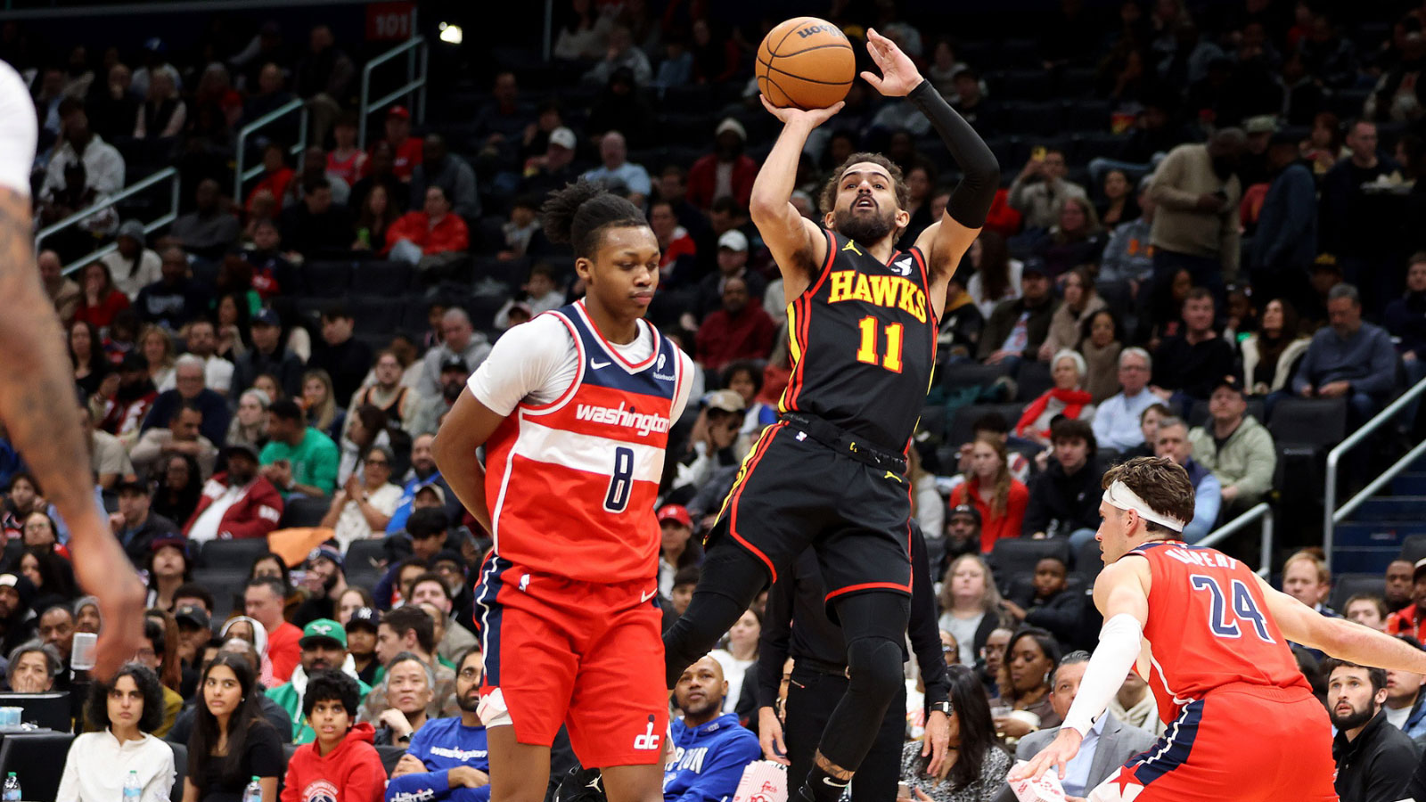 Atlanta Hawks guard Trae Young (11) shoots against Washington Wizards guard Bub Carrington (8) during the first half at Capital One Arena.