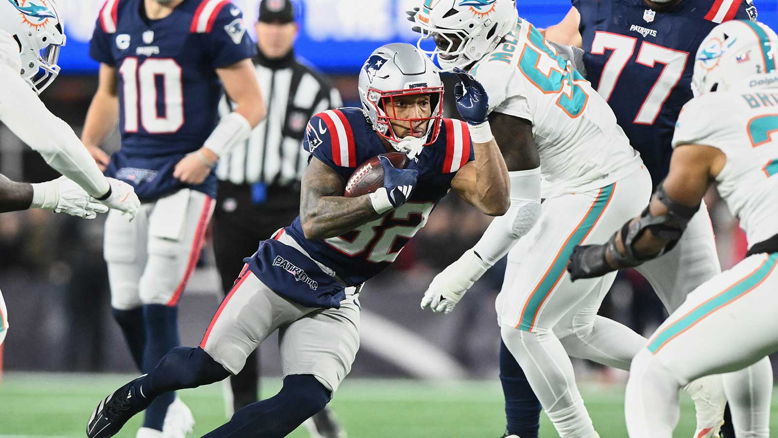 New England Patriots running back TreVeyon Henderson (32) runs the ball against Miami Dolphins center Aaron Brewer (55) during the first quarter at Gillette Stadium.