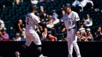 Colorado Rockies right fielder Tyler Freeman (2) reacts with first base coach Ronnie Gideon (53) on an RBI single in the second inning against the Miami Marlins at Coors Field.