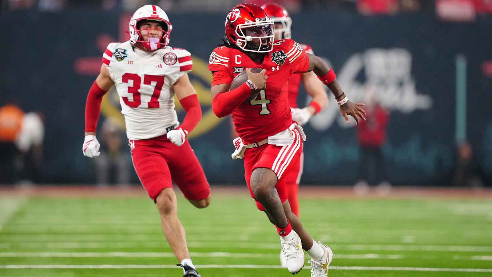 Utah Utes quarterback Devon Dampier (4) carries the ball against Nebraska Cornhuskers defensive back Donovan Jones (37) in the second half during the SRS Distribution Las Vegas Bowl at Allegiant Stadium. 