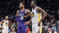 Warriors forward Draymond Green (23) chats with Charlotte Hornets forward Kon Knueppel at the free throw line during the second half at Spectrum Center