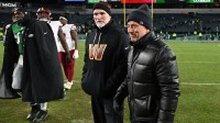 Washington Commanders head coach Dan Quinn and owner Josh Harris on the field after a win against the Philadelphia Eagles at Lincoln Financial Field.