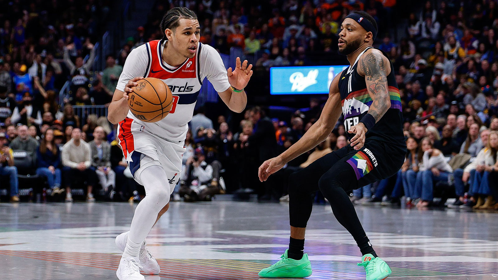 Washington Wizards forward Kyshawn George (18) controls the ball as Denver Nuggets guard Bruce Brown (11) guards in the fourth quarter at Ball Arena.
