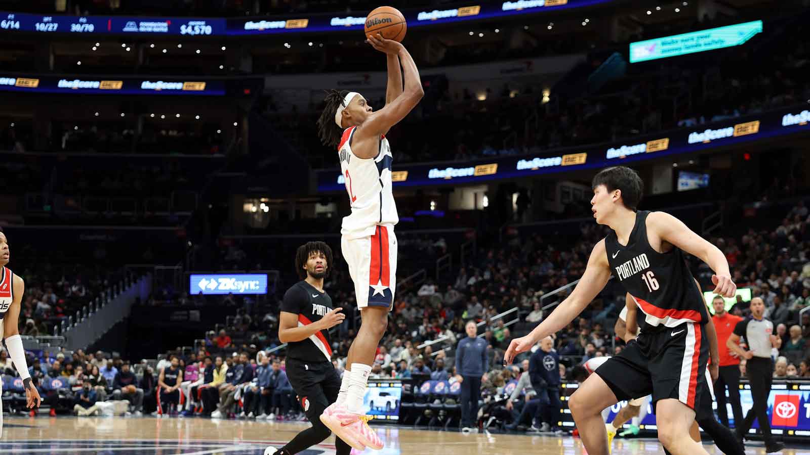 Washington Wizards guard Tre Johnson (12) takes a shot over Portland Trail Blazers center Yang Hansen (16) during the second half at Capital One Arena.