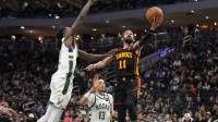 Atlanta Hawks guard Trae Young (11) shoots around Milwaukee Bucks forward Taurean Prince (12) during the third quarter at Fiserv Forum.