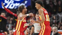 Atlanta Hawks forward Zaccharie Risacher (10) reacts with guard Trae Young (11) after making a three point basket for his first points in the NBA against the Brooklyn Nets during the first half at State Farm Arena.