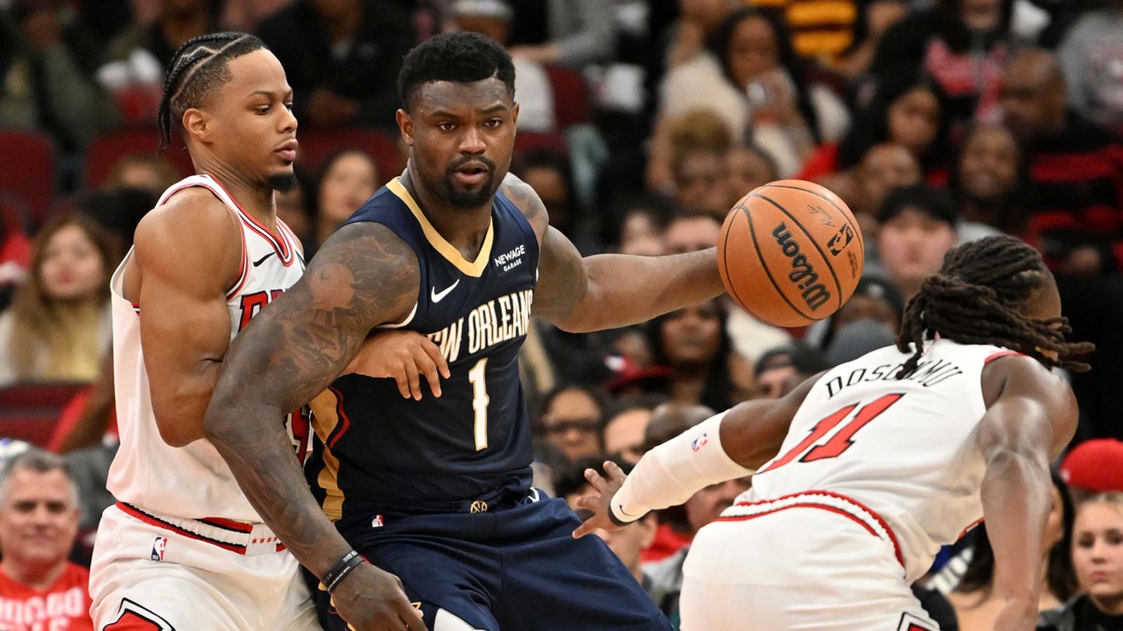 New Orleans Pelicans forward Zion Williamson (1) controls the ball against Chicago Bulls forward Isaac Okoro (35) and guard Ayo Dosunmu (11) during the first half at United Center.