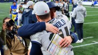 Seattle Seahawks quarterback Sam Darnold (14) hugs offensive coordinator Klint Kubiak after defeating the Los Angeles Rams in overtime at Lumen Field.