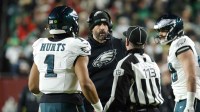 Philadelphia Eagles head coach Nick Sirianni talks with quarterback Jalen Hurts (1) and an official during the first half against the Washington Commanders at Northwest Stadium.