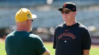 San Francisco Giants manager Bob Melvin (6) talks with Oakland Athletics manager Mark Kotsay (7) before the final game between the Oakland Athletics and the San Francisco Giants at Oakland-Alameda County Coliseum.