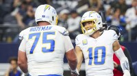 Los Angeles Chargers quarterback Justin Herbert (10) celebrates with center Bradley Bozeman (75) after rushing for a touchdown against the Dallas Cowboys during the second quarter at AT&T Stadium.
