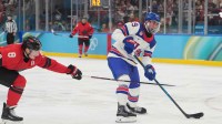 Brock Nelson (29) of the United States is defended by Cale Makar (8) of Canada in the men's ice hockey gold medal game during the Milano Cortina 2026 Olympic Winter Games at Milano Santagiulia Ice Hockey Arena.