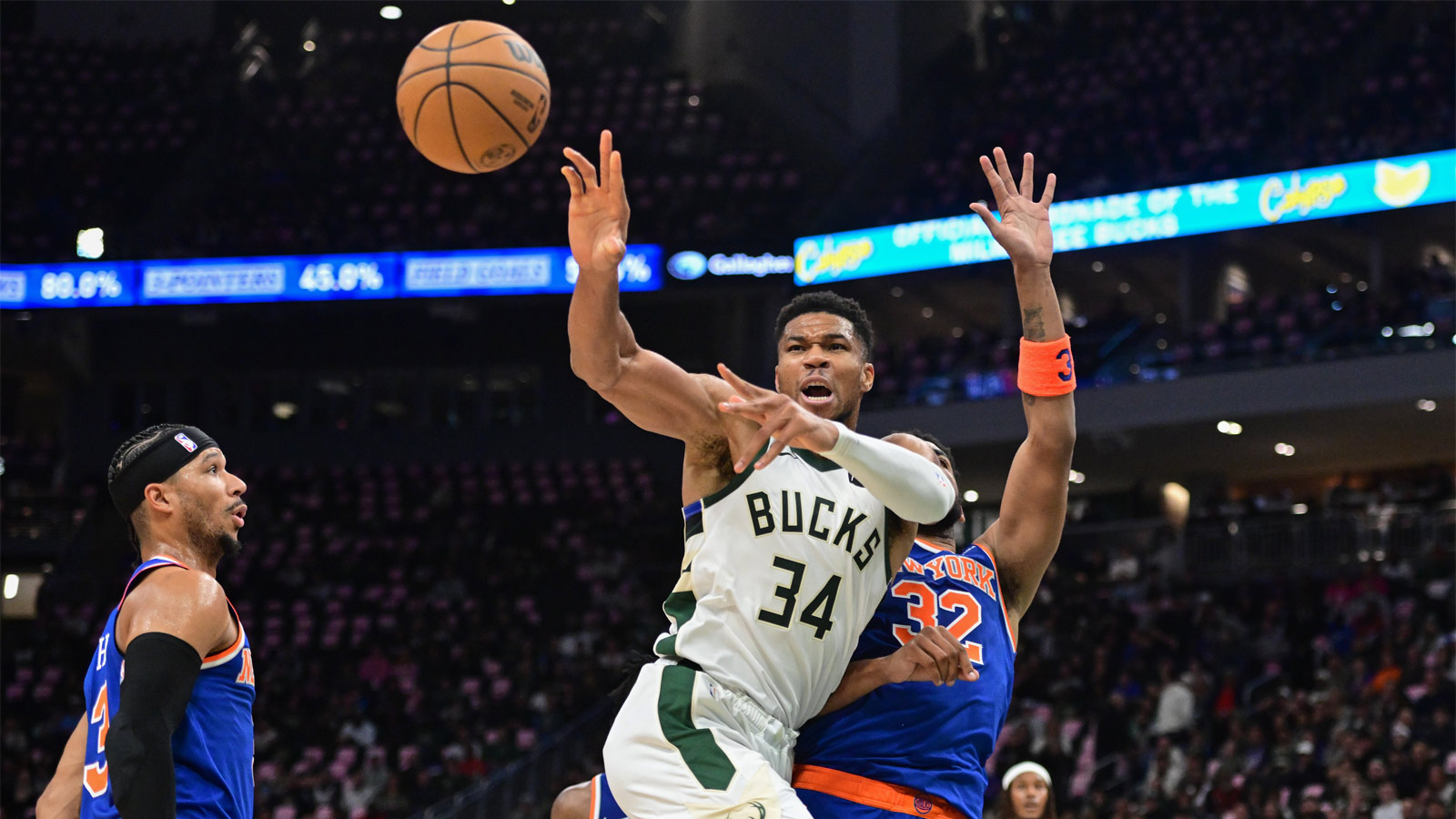 Bucks forward Giannis Antetokounmpo (34) passes the ball away from New York Knicks center Karl-Anthony Towns (32) in the second quarter at Fiserv Forum