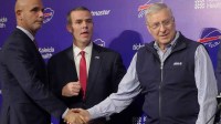 Pete Guelli, president of business operations, Brandon Beane, president of football operations and general manager, shake hands with owner and president Terry Pegula after a group photo with new Bills head coach Joe Brady on Jan. 29, 2026 at the Bills field house.