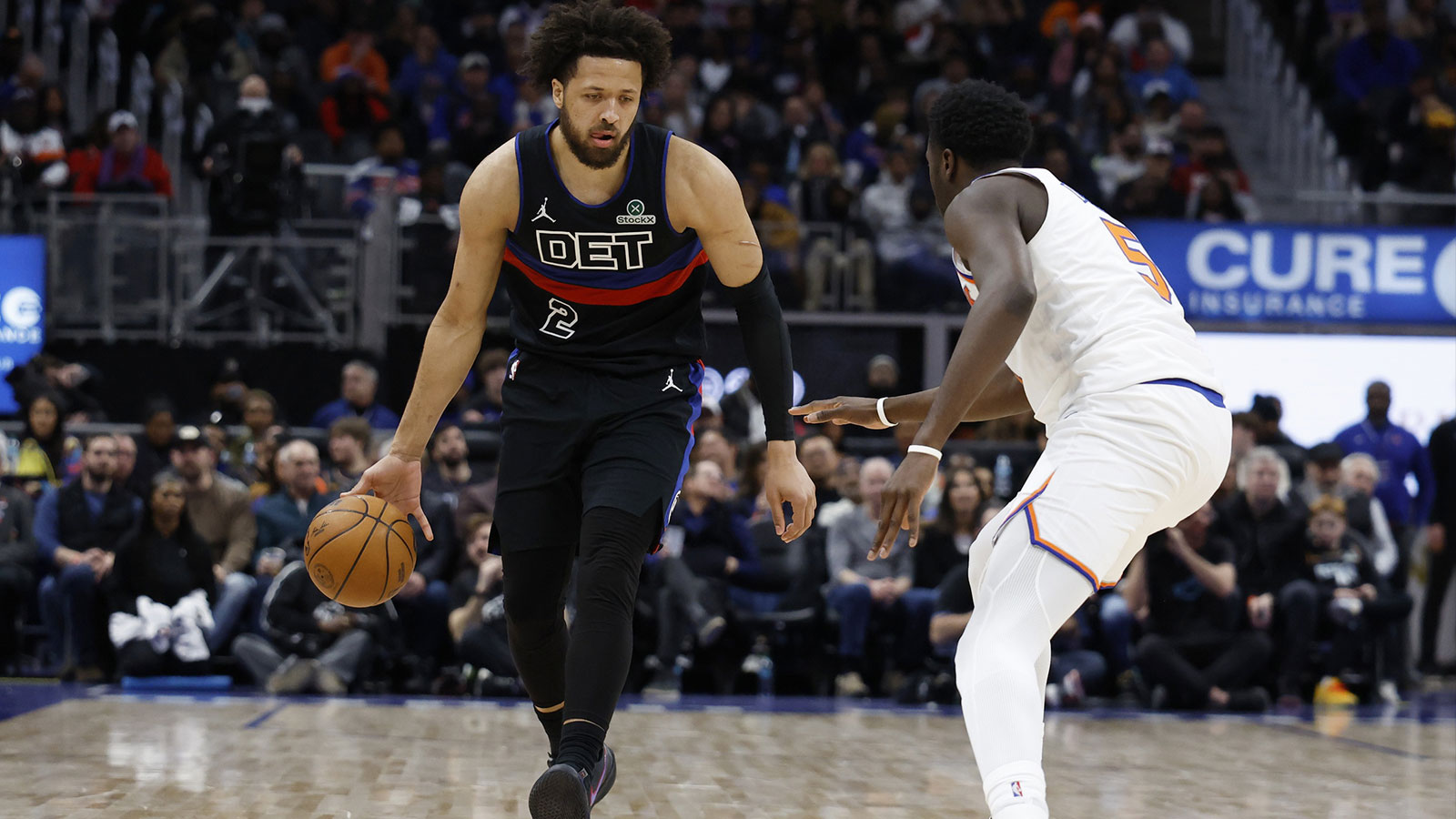 Detroit Pistons guard Cade Cunningham (2) dribbles defended by New York Knicks forward Mohamed Diawara (51) in the second half at Little Caesars Arena.