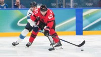 Brad Marchand (63) of Canada chases the puck as Niko Mikkola (77) of Finland defends during the second period in a men's ice hockey semifinal during the Milano Cortina 2026 Olympic Winter Games at Milano Santagiulia Ice Hockey Arena.