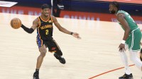 Thunder guard Shai Gilgeous-Alexander (2) passes the ball while defended by Boston Celtics guard Jaylen Brown (7) during the first quarter at Paycom Center with Tracy McGrady in the background