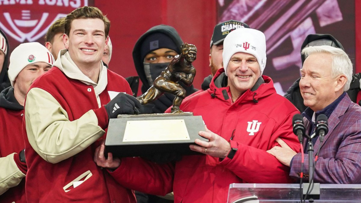 Indiana Hoosiers quarterback Fernando Mendoza (15) holds the Heisman Trophy with Indiana Hoosiers head coach Curt Cignetti on Saturday, Jan. 24, 2026, during the Indiana Football College Football Playoff National Championship celebration and parade at Memorial Stadium in Bloomington.