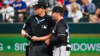 Miami Marlins manager Clayton McCullough (86) talks with umpire Stu Scheurwater (85) as he makes lineup changes during the eighth inning against the Texas Rangers at Globe Life Field