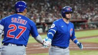 Chicago Cubs outfielder Ian Happ (8) slaps hands with Chicago Cubs outfielder Seiya Suzuki (27) after hitting a solo home run against the Arizona Diamondbacks during the fourth inning at Chase Field.