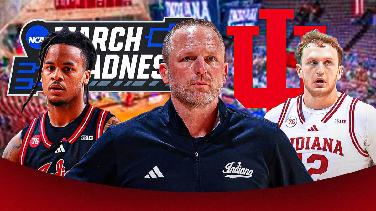 Indiana HC Darian DeVries (center) with Indiana PG Lamar Wilkerson and Indiana SF Tucker DeVries. Indiana Hoosiers logo and Big Ten March Madness logo behind them.