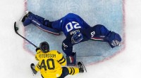 Damian Clara of Italy in action with Elias Pettersson of Sweden in men's ice hockey group B play during the Milano Cortina 2026 Olympic Winter Games at Milano Santagiulia Ice Hockey Arena.