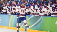 Dylan Larkin (21) of the United States celebrates with the bench after scoring a goal during the first period against Slovakia in a men's ice hockey semifinal during the Milano Cortina 2026 Olympic Winter Games at Milano Santagiulia Ice Hockey Arena.
