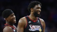 Philadelphia 76ers center Joel Embiid (21) and guard Vj Edgecombe (77) share a lighter moment during the fourth quarter against the New Orleans Pelicans at Xfinity Mobile Arena.