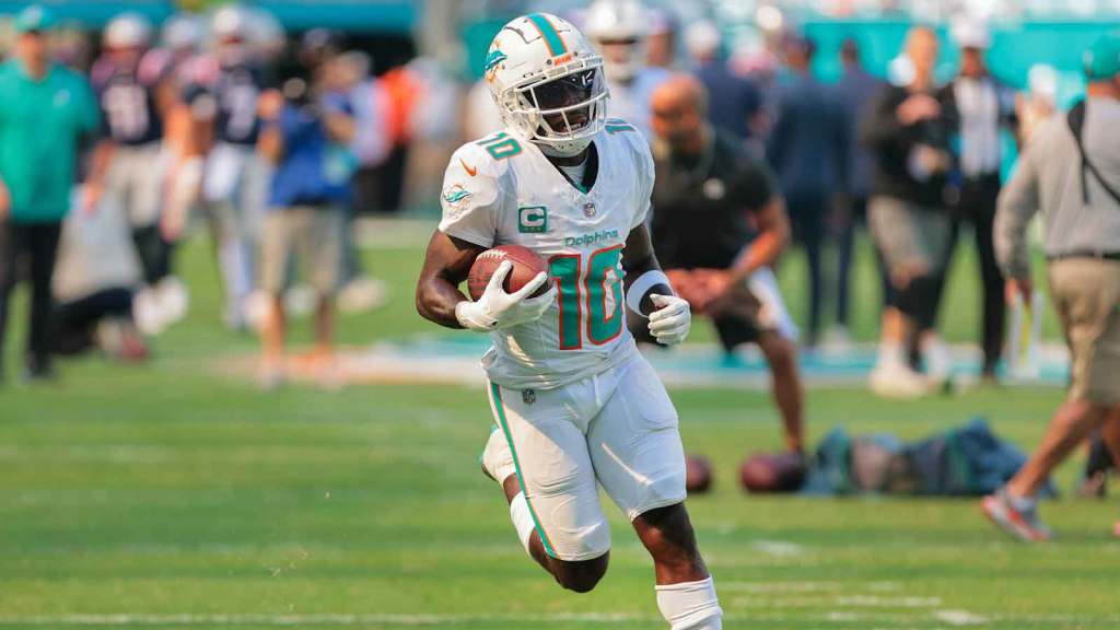 Miami Dolphins wide receiver Tyreek Hill (10) runs with the football before the game against the New England Patriots at Hard Rock Stadium.