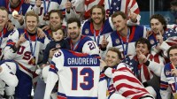 United States players celebrate with a team photo while holding the jersey of Johnny Gaudreau after defeating Canada in the men's ice hockey gold medal game during the Milano Cortina 2026 Olympic Winter Games at Milano Santagiulia Ice Hockey Arena.
