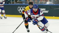 Quinn Hughes of United States in action with Joshua Samanski of Germany in men's ice hockey group C play during the Milano Cortina 2026 Olympic Winter Games at Milano Santagiulia Ice Hockey Arena.