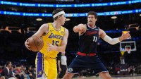 Los Angeles Lakers guard Austin Reaves (15) dribbles the ball against LA Clippers center Brook Lopez (11) in the first half at Crypto.com Arena.