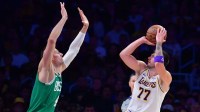 Los Angeles Lakers guard Luka Doncic (77) shoots against Boston Celtics center Nikola Vucevic (4) during the first half at Crypto.com Arena.