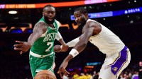 Feb 22, 2026; Los Angeles, California, USA; Boston Celtics guard Jaylen Brown (7) and Los Angeles Lakers center Deandre Ayton (5) play for the ball during the second half at Crypto.com Arena.