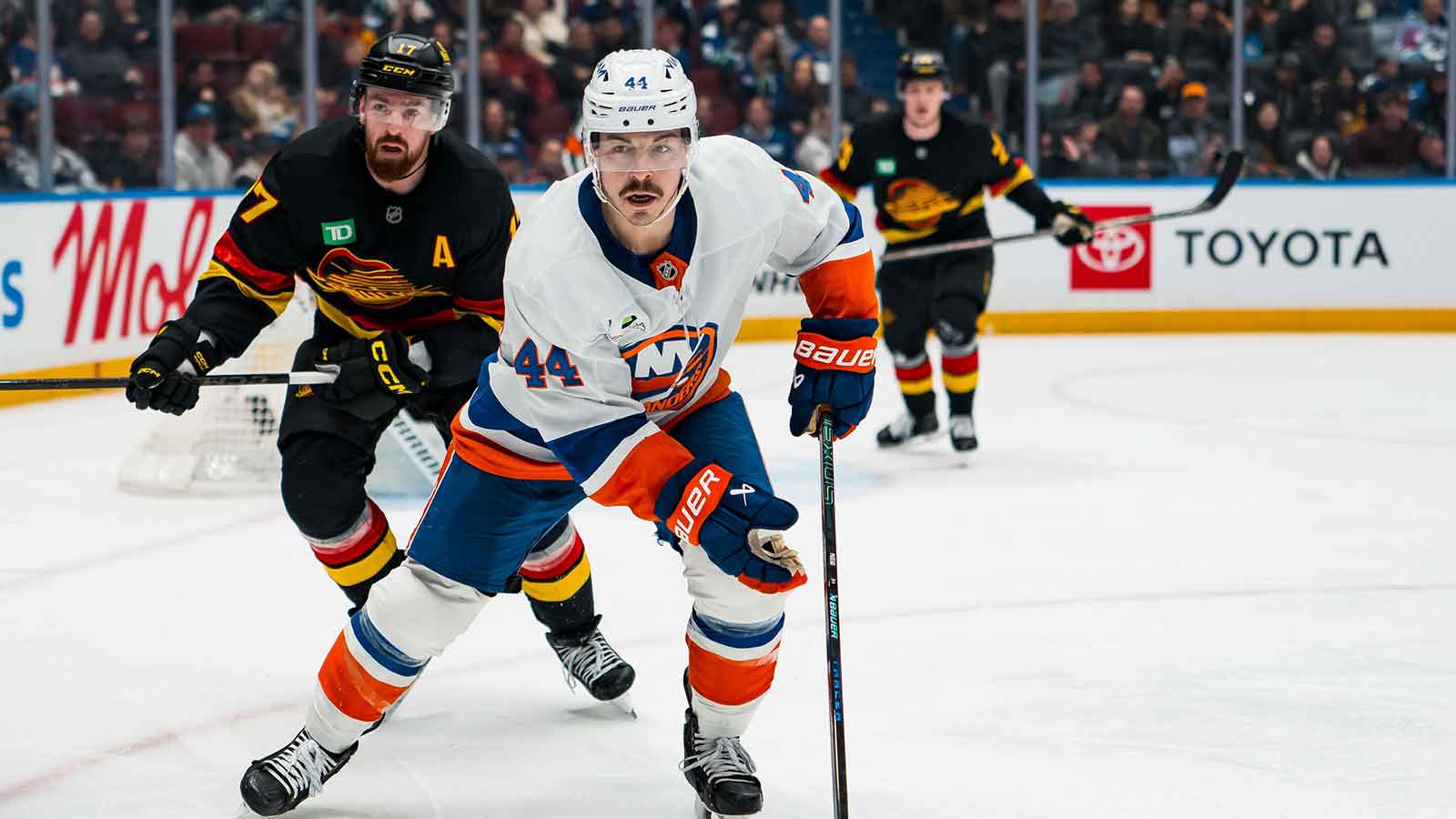 Vancouver Canucks defenseman Filip Hronek (17) and New York Islanders forward Jean-Gabriel Pageau (44) look for the loose puck in the third period at Rogers Arena