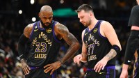 Los Angeles Lakers forward/guard Luka Doncic (77) talks with Los Angeles Lakers forward LeBron James (23) against the Washington Wizards during the second half at Capital One Arena.