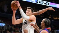 Jazz center Walker Kessler (24) goes in for a layup over Toronto Raptors guard AJ Lawson (0) in the second half at Scotiabank Arena with the Pacers logo in the background