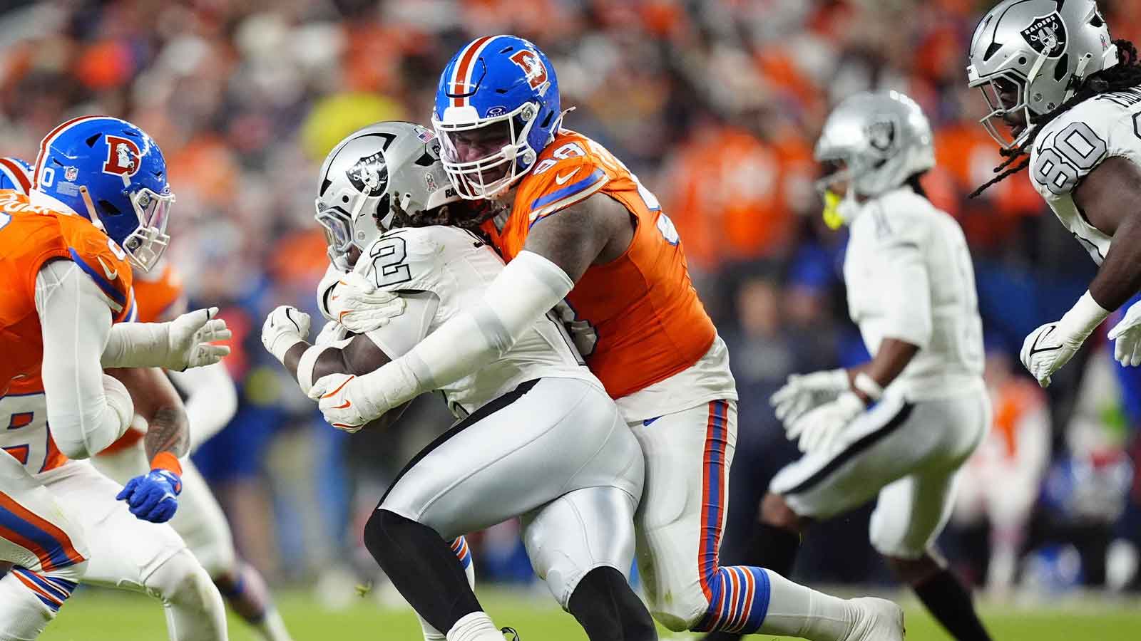 Denver Broncos defensive end John Franklin-Myers (98) makes a tackle on Las Vegas Raiders running back Ashton Jeanty (2) during the second half at Empower Field at Mile High. 
